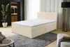 A beige boxspring bed with a white mattress topper is shown in a bedroom setting. The bed has storage drawers. A large plant is visible in the background. Voir les images du produit