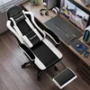 A gaming chair is set up at a desk with a computer and accessories. Voir les images du produit