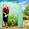 A man is tending to plants inside a green greenhouse. Náhľad obrázku produktu