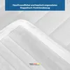 A close-up view of a white mattress topper with quilted stitching and a blue banner at the top with text. Produktbild-Vorschau