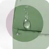 A close-up view of a green fabric with a water droplet on it, highlighting its water-repellent properties. Náhľad obrázku produktu