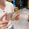 A person holding a phone with a magnetic charger attached. Náhled obrázku produktu