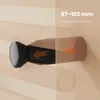 A close-up of an adjustable mounting bracket for a towel warmer, with arrows indicating adjustment range and text specifying dimensions. Podgląd zdjęcia produktu
