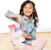 A young girl is sitting on the floor, holding a pink backpack and pulling out a card with a Disney Princess character on it. Náhľad obrázku produktu