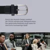 A close-up of a belt buckle and strap, with a group of people walking in the background. Produktbild-Vorschau