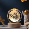 A crystal ball lamp with a 3D moon design sits on a wooden base, with an astronaut figurine in the background. Náhled obrázku produktu