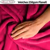 A hand is shown resting on a pink fluffy blanket, highlighting its texture. Produktbild-Vorschau
