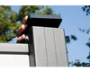 A hand is shown placing a black cap on top of a gray fence post. Produktbild-Vorschau