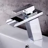 A close-up shot of a modern chrome waterfall faucet installed on a white sink. Náhled obrázku produktu