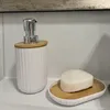 A white soap dispenser and a soap dish with a bar of soap on a white sink. Voir les images du produit