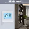 A digital thermostat is mounted on a wall next to a bookshelf in a room. Náhled obrázku produktu