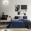 A bedroom scene with a floor lamp, bed, and wall art. Produktbild-Vorschau