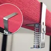Close-up of a stainless steel tablecloth clip holding a red fabric. Produktbild-Vorschau