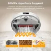 A robot vacuum cleaner is shown from underneath, demonstrating its suction power and ability to pick up various debris. Produktbild-Vorschau