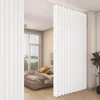 A bedroom divided by a white accordion curtain, with a bed visible in the background. Náhled obrázku produktu