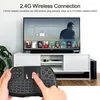 A hand holding a wireless keyboard with a TV in the background. Produktbild-Vorschau