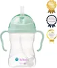 A mint green baby bottle with handles and a straw, shown against a white background. Several award badges are visible on the right side of the image. Produktbild-Vorschau