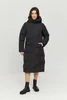 A woman wearing a black puffer coat and boots, standing against a white background. Produktbild-Vorschau