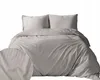 A neatly made bed with a duvet and two pillows, all in a light beige color with subtle vertical stripes. A close-up inset shows the texture of the fabric. Anteprima dell’immagine prodotto