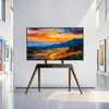 A TV stand with a TV displaying a landscape painting, set in a modern art gallery. Podgląd zdjęcia produktu