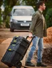A man is pulling a rolling tool chest on a dirt path next to a van. Voir les images du produit