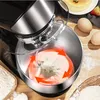 A kitchen mixer with dough being kneaded, surrounded by baking ingredients. Produktbild-Vorschau