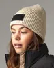 A woman wearing a beanie and a puffer jacket. Anteprima dell’immagine prodotto