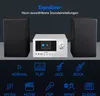 A silver micro audio system with two black speakers, set against a dark gray background. Below the system are icons representing different sound settings. Produktbild-Vorschau