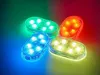 Four oval-shaped LED lights, each emitting a different color of light (green, blue, orange, and yellow) onto a dark background. Produktbild-Vorschau