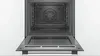 An open oven with its door lowered, showing the interior. Produktbild-Vorschau