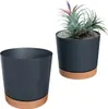 Two dark gray planters with brown bases are shown against a white background. One planter is empty, and the other contains a small plant. Náhled obrázku produktu