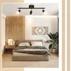 A bedroom scene featuring a bed, nightstand, and a track light fixture. Produktbild-Vorschau