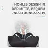 A black and gray orthopedic seat cushion with arrows indicating airflow, overlaid on a faint image of a spine. Produktbild-Vorschau