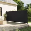A black retractable side awning is extended on a wooden deck next to a house. Produktbild-Vorschau