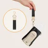 A hand holding a strap attached to a bottle warmer with a baby bottle inside. Produktbild-Vorschau