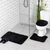 A bathroom scene with a toilet, shower, and bath mats. Produktbild-Vorschau