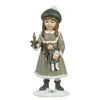 A decorative figurine of a girl holding a doll and a candle, standing on a snowy base. Voir les images du produit