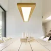 A modern dining room with a wooden table and chairs, illuminated by a triangular pendant light. Náhľad obrázku produktu