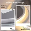 Close-up details of a round mirror with integrated LED lighting, highlighting its matte texture and aluminum metal frame. Produktbild-Vorschau