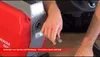 A person is connecting a tool to a red and gray pipe cleaning machine. Podgląd zdjęcia produktu