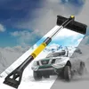 A snow brush and ice scraper for a car, set against a snowy mountain backdrop with a car driving through snow. Voir les images du produit