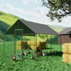 A chicken coop with a shaded roof is set up in a grassy field with hay bales and a wooden barn in the background. Several chickens and ducks are visible inside and around the coop. Anteprima dell’immagine prodotto