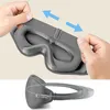 A close-up of a grey sleep mask, showing its adjustable strap and plush material. The bottom part of the image shows a different angle of the mask with a logo. Náhled obrázku produktu