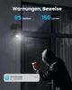 A burglar is attempting to break into a house at night, illuminated by a security light. An alert message is displayed on a phone. Produktbild-Vorschau