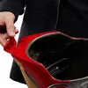 A close-up shot of a person's hand opening a red and gold Iron Man helmet. Podgląd zdjęcia produktu