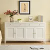 A white sideboard with drawers and doors, decorated with a vase of flowers, a bowl of grapes, and framed pictures. Produktbild-Vorschau