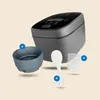 A rice cooker and its accessories are displayed against a light beige background. Produktbild-Vorschau