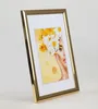 A gold picture frame with a portrait of a woman adorned with flowers inside. Produktbild-Vorschau
