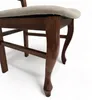 A close-up view of the wooden legs and upholstered seat of a chair. Produktbild-Vorschau