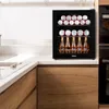 A beverage cooler filled with cans and bottles sits on a kitchen counter next to a sink. Voir les images du produit